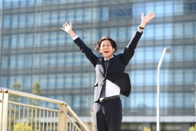 両手を挙げて喜ぶ男性